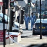 Police forensic officers walk down a road close to where a vehicle collided with pedestrians in the Finsbury Park neighborhood of London