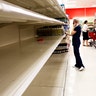 Kailey Coventry walks past empty shelves of water at Target in Gainesville, Fla., on Wednesday