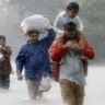 Residents wade through flood waters from Tropical Storm Harvey in Beaumont Place, Houston, Monday