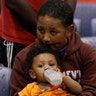 Evacuee Edward Jones, 11, holds his step-brother Mickel Duane Batts at the Lakewood Church in Houston, Tuesday