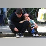A man comforts a boy after the apartment building fire, in north Kensington, West London