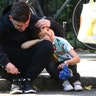 A man comforts a boy after the apartment building fire, in north Kensington, West London