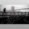 Snow falls as a jogger, framed by the Brooklyn Bridge, runs underneath the Franklin Delano Roosevelt Drive overpass.