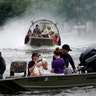 People are rescued from flood waters from Hurricane Harvey on an air boat in Dickinson, Texas, Sunday