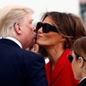 President Donald Trump and first lady Melania Trump kiss on the tarmac after arriving on Air Force One at Orly Airport in Paris