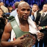 Floyd Mayweather Jr. wears the money belt after defeating Conor McGregor in a super welterweight boxing match Saturday