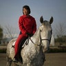 Pak Hyon Sun, 18, poses on a horse at the Mirim Riding Club, in Pyongyang, North Korea, April 20, 2017