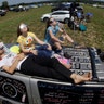Jonathan Billing, Mary Ludwig, and Emily Ludwig, watch the solar eclipse from the roof of their vehicle in Hopkinsville, Kentucky