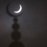 A partial solar eclipse is seen above a mosque in Oxford, England, March 20, 2015