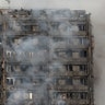 Smoke billows from the tower block destroyed by the fire, in West London