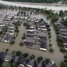 Homes are surrounded by floodwaters from Tropical Storm Harvey Tuesday, in Spring, Texas