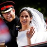 Prince Harry and his wife Meghan wave as they ride in a horse-drawn carriage after their wedding ceremony