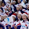 Fans from North Korea wave Korean unification flags during women's hockey game between Sweden and Korea