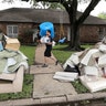 Michael Saghian helps remove items damaged by floodwaters from Tropical Storm Harvey from his home in Houston, August 30, 2017