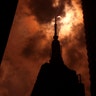 The sun is eclipsed by the moon over top of the Empire State Building in New York City, August 21