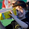 Griffin O'Roak watches the rising sun with his homemade eclipse viewer at a gathering of eclipse viewers in Salem, Oregon