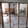 Jose Martinez works to remove drywall from a home damaged by floodwaters from Tropical Storm Harvey in Houston, Wednesday