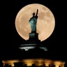 A supermoon rises in front of a replica of the Statue of Liberty sitting atop the Liberty Building in Buffalo, N.Y., December 3