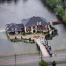 A home is surrounded by floodwaters from Tropical Storm Harvey in Houston, Tuesday
