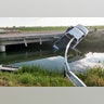  The pickup took out several yards of steel guard rail and was left partially dangling in the water