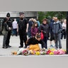 A woman leaves flowers at the south end of London Bridge, near Borough Market