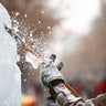 An artist polishes an ice sculpture. 