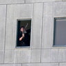 An armed man stands in a window of the parliament building in Tehran