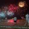 People watch the fireworks exploding over Copacabana beach during the New Year's Eve celebrations in Rio de Janeiro, Brazil, Sunday, Jan. 1, 2017.