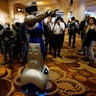 A man in a mechanized robotic costume points the way for showgoers to the CES Unveiled event at CES in Las Vegas.