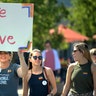 Suzy Berschback carries a Love is Love sign as she marches with her daughter, Maddie Berschback, and her friend, Kelsie Silzell, in Michigan