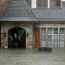 A man standing in the doorway of his flooded home responds to an evacuation offer in a neighborhood in Houston, Monday