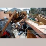 Gregory Rugon looks for his glasses at the spot where he took cover in his home after the tornado.