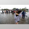 Mikhail Bachynsky hugs her dog Lily after they were rescued from their home Sunday in the Friendswood area of Houston
