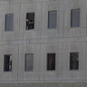 An Iranian policeman looks out of the parliament's building