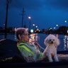 A woman and her poodle wait on an air mattress to be rescued from flood waters on Scarsdale Boulevard in Houston, Texas, Sunday