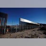A worker stands next to a newly built section of the U.S.-Mexico border fence at Sunland Park, opposite the Mexican border city of Ciudad Juarez.