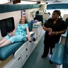 Natalie Burgess of Temple Beth Orr gives blood during an emergency blood drive in Coral Springs, Fla., Wednesday