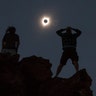 Tanner Person and Josh Blinkwatch a total solar eclipse atop Carroll Rim Trail at Painted Hills near Mitchell, Oregon