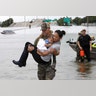  Houston Police SWAT officer Daryl Hudeck carries Catherine Pham and her son Aiden after rescuing them in Houston, Sunday