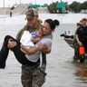  Houston Police SWAT officer Daryl Hudeck carries Catherine Pham and her son Aiden after rescuing them in Houston, Sunday