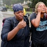 Domenique Scales wipes tears from her face after being rescued from the flood waters in Beaumont Place, Texas, Monday