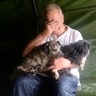 An evacuee holding two dogs reacts after his rescue by Texas National Guardsmen in Cypress Creek, Houston, Tuesday