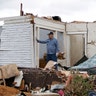 Man_Stands_in_Living_Room_Wreckage_AP