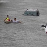 Jesus Rodriguez rescues Gloria Garcia after rain from Hurricane Harvey flooded Pearland, in the outskirts of Houston, Texas, Sunday