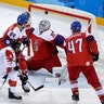 Andrew Ebbett of Canada shoots the puck past goalie Pavel Francouz of the Czech Republic