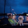 A woman and her poodle wait on an air mattress to be rescued from flood waters on Scarsdale Boulevard in Houston, Sunday