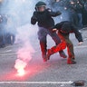 A German riot policemen catches a protester during the demonstrations at the G-20 summit in Hamburg, Germany