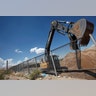 An excavator removes a fence to be replaced by a section of the border wall at Sunland Park, U.S., opposite Ciudad Juarez, Mexico.