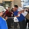 A customer jumps into the arms of an Apple employee