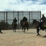 The border patrol on horses in front of the wall